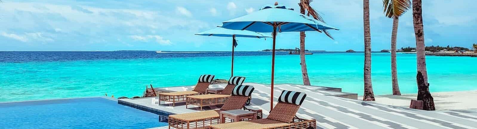 brown wooden lounge chairs on beach during daytime